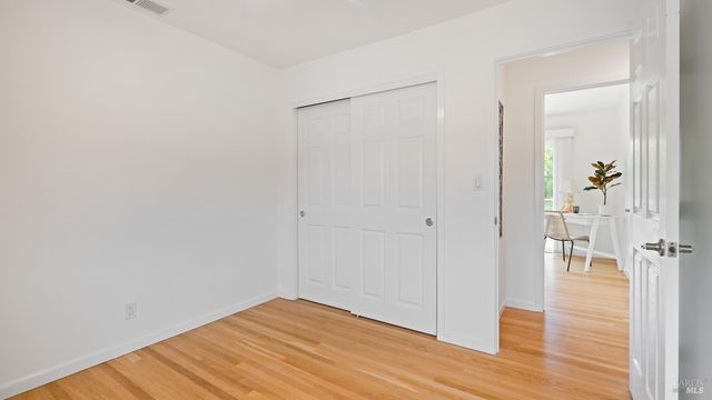 a view of empty room with wooden floor