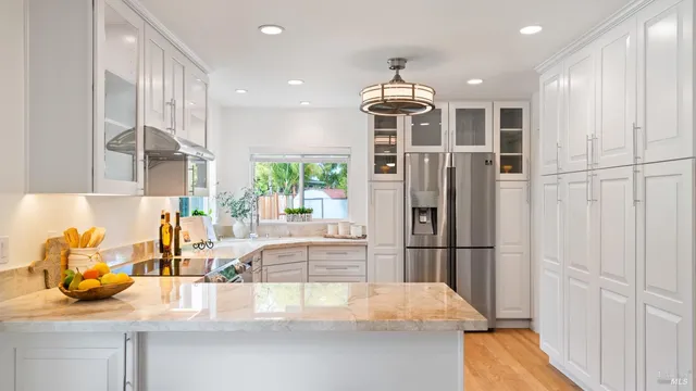 a kitchen with stainless steel appliances granite countertop a refrigerator and a sink