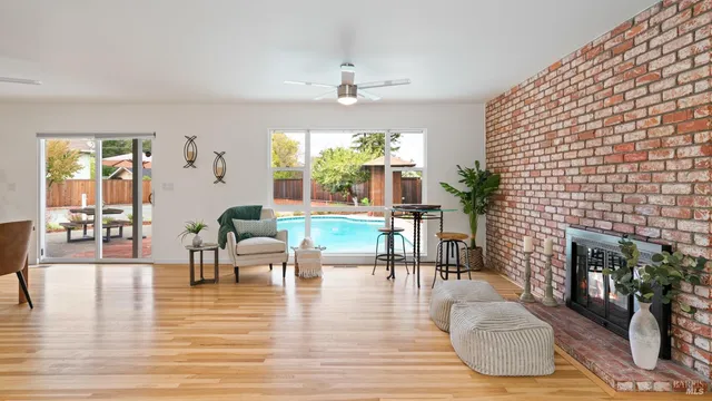 a living room with fireplace furniture and a large window