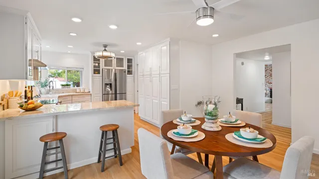 a dining room with stainless steel appliances furniture a dining table and chairs