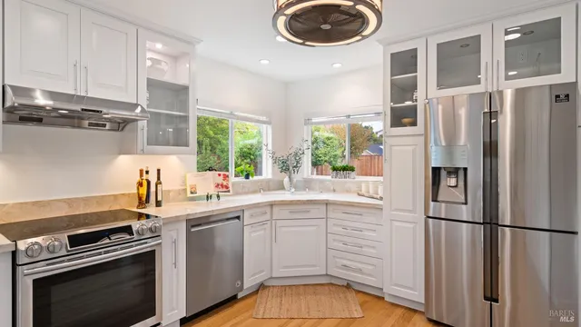 a kitchen with a sink stainless steel appliances a stove and a refrigerator