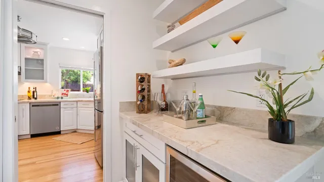 a kitchen with a sink a counter appliances and wooden floor