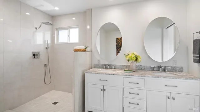 a bathroom with a granite countertop sink a mirror and a shower