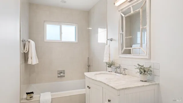 a bathroom with a sink vanity tub and a mirror