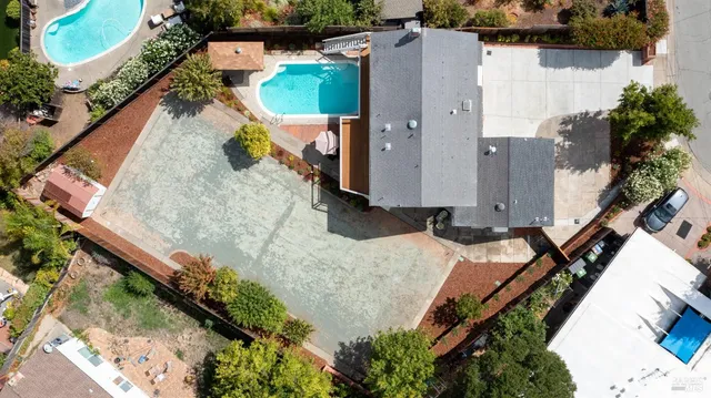 an aerial view of a house with a yard and trees
