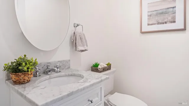 a bathroom with a granite countertop sink a toilet and a mirror