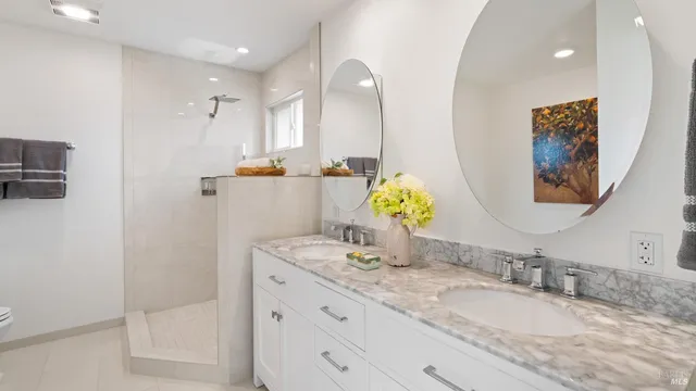 a bathroom with a granite countertop double vanity sink and a mirror