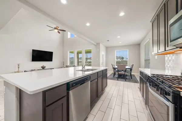 a kitchen with sink stove and cabinets