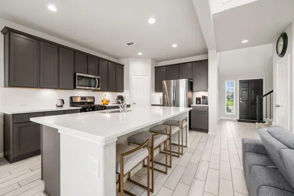 a kitchen with stainless steel appliances a refrigerator a stove a sink dishwasher and a oven with wooden cabinets