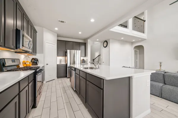 a kitchen with stainless steel appliances a sink stove and refrigerator