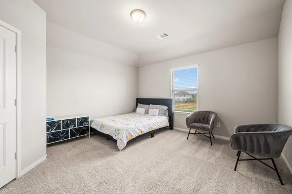 a bedroom with a bed and a chair