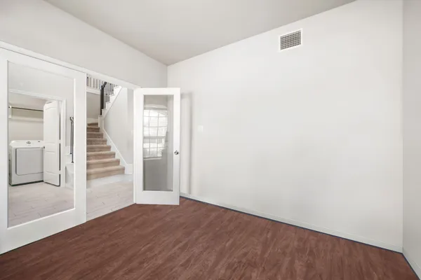 a view of a hallway with wooden floor and entryway