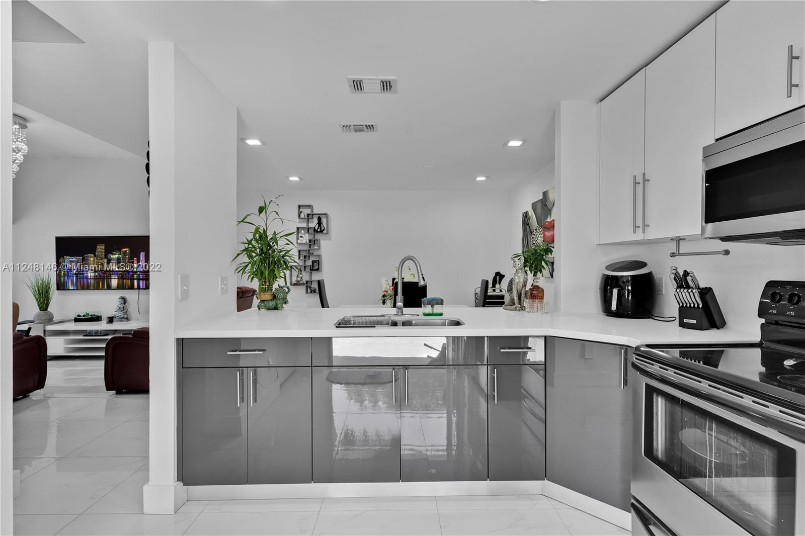 10505 Southwest 153rd Court, Unit 2 Miami, FL 33196 - Photo 29 of 39 a kitchen with stainless steel appliances granite countertop a sink a stove and cabinets