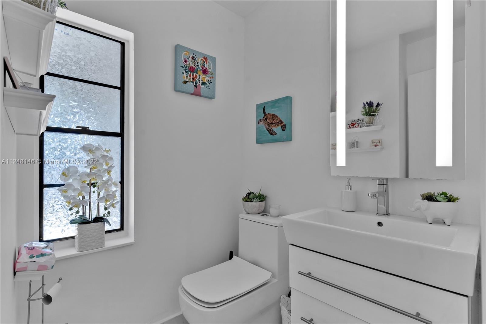 10505 Southwest 153rd Court, Unit 2 Miami, FL 33196 - Photo 32 of 39 a bathroom with a toilet sink and mirror