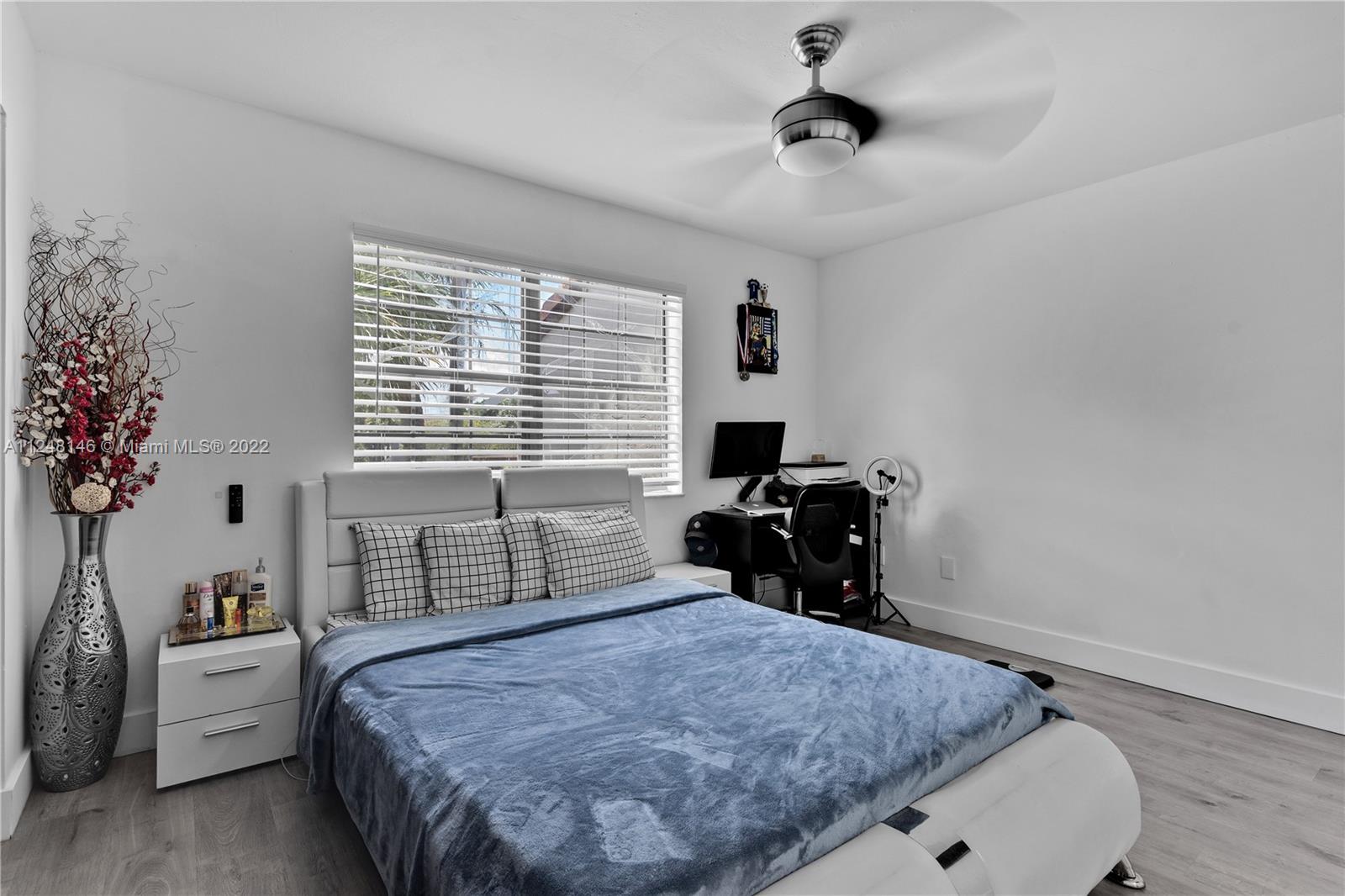 10505 Southwest 153rd Court, Unit 2 Miami, FL 33196 - Photo 34 of 39 a bedroom with a bed and a chandelier