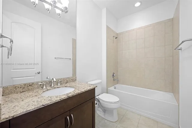 a bathroom with a granite countertop sink a toilet and shower