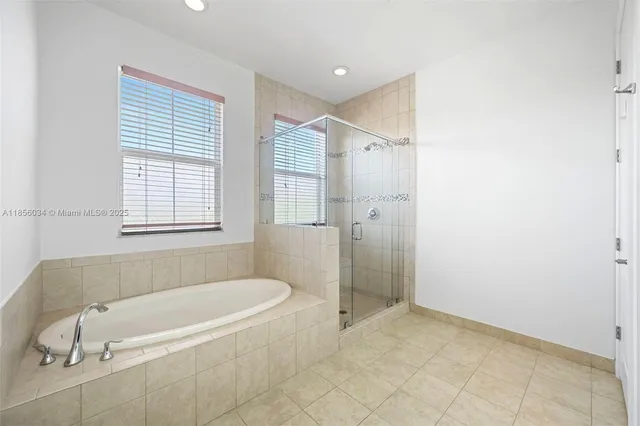 a white bath tub sitting in a bathroom next to a window