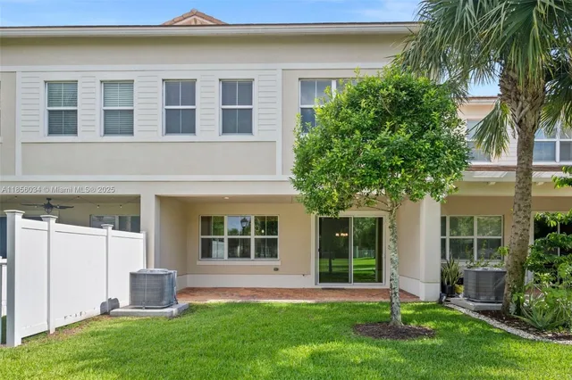 a front view of a house with a yard and potted plants