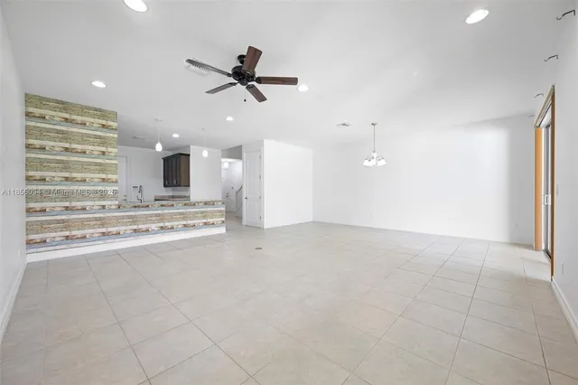 a view of an empty room and kitchen view
