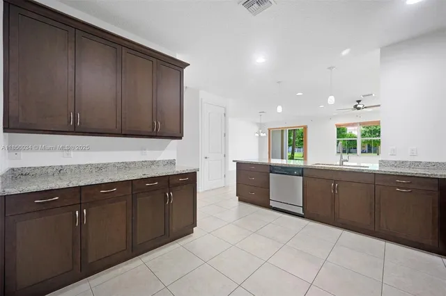 a large kitchen with granite countertop a sink and cabinets