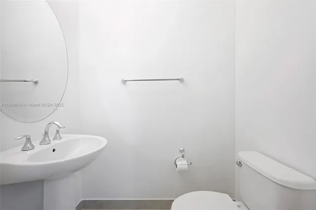 a bathroom with a sink mirror and toilet