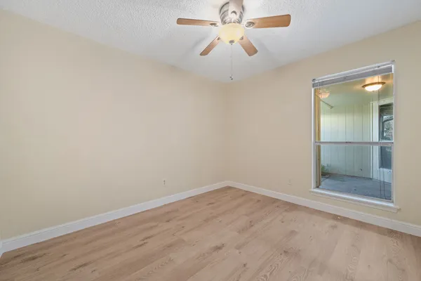 an empty room with closet and a chandelier fan