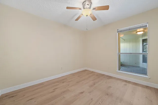 an empty room with closet and a chandelier fan