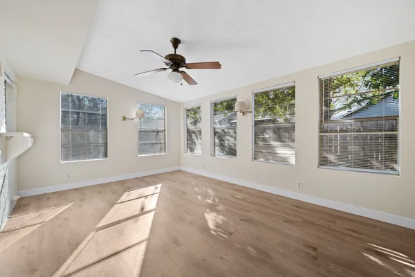 a view of an empty room with a window and wooden floor