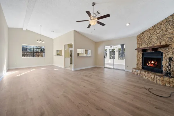 a view of an empty room with a fireplace and a window