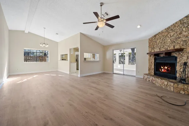 a view of an empty room with a fireplace and a window