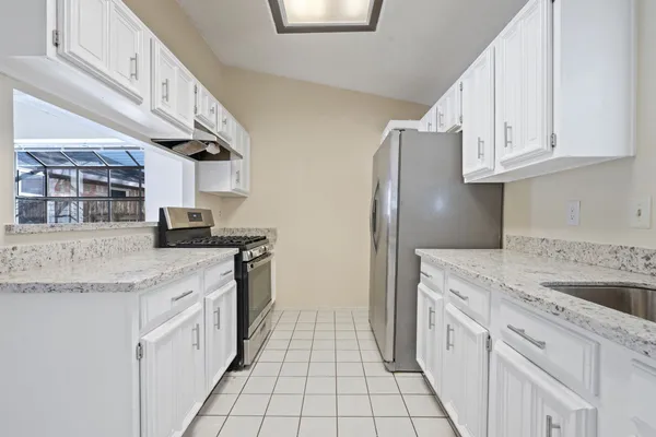 a kitchen with granite countertop a sink stove and cabinets
