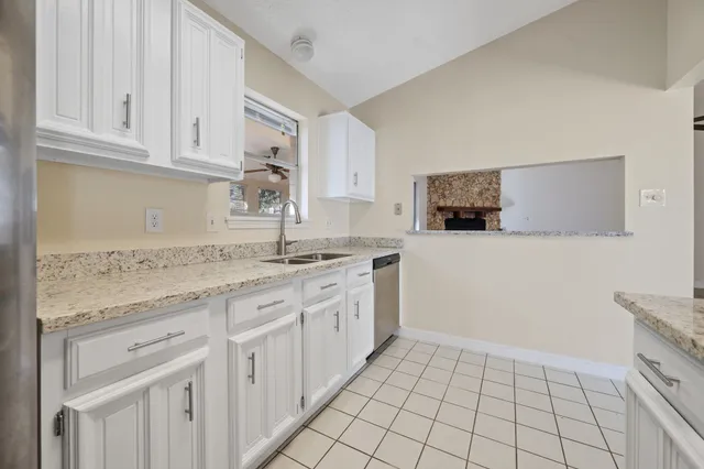 a kitchen with granite countertop white cabinets and stainless steel appliances