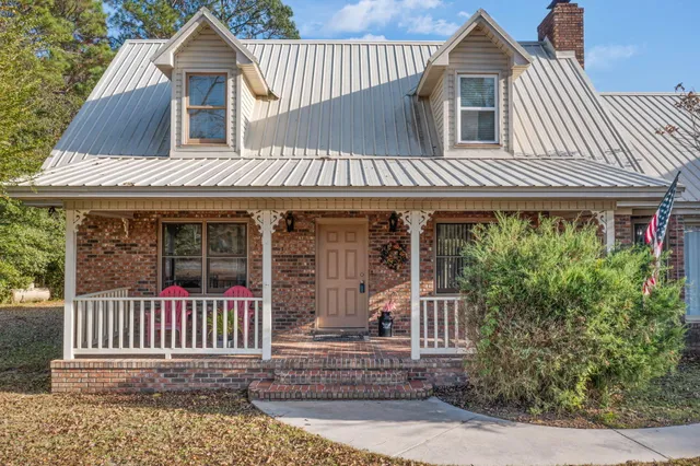 a view of a house next to a yard with big trees