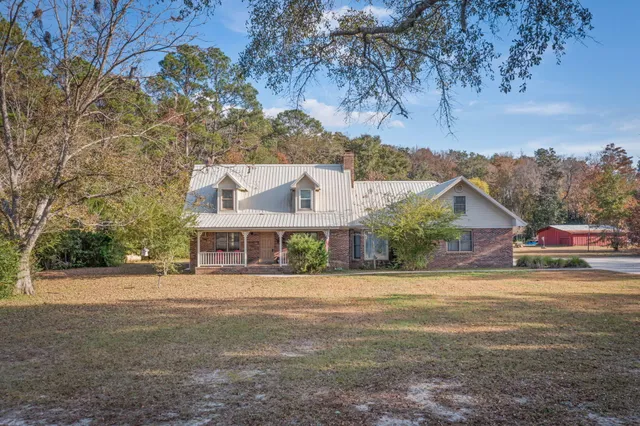 a front view of a house with a yard and potted plants