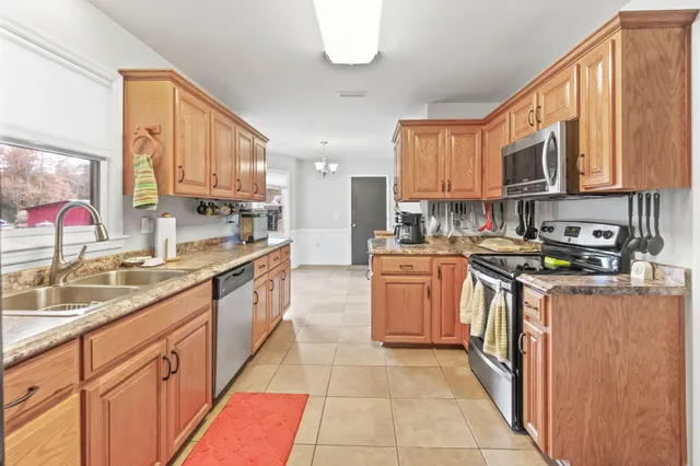 a kitchen with stainless steel appliances granite countertop a stove a sink and a microwave