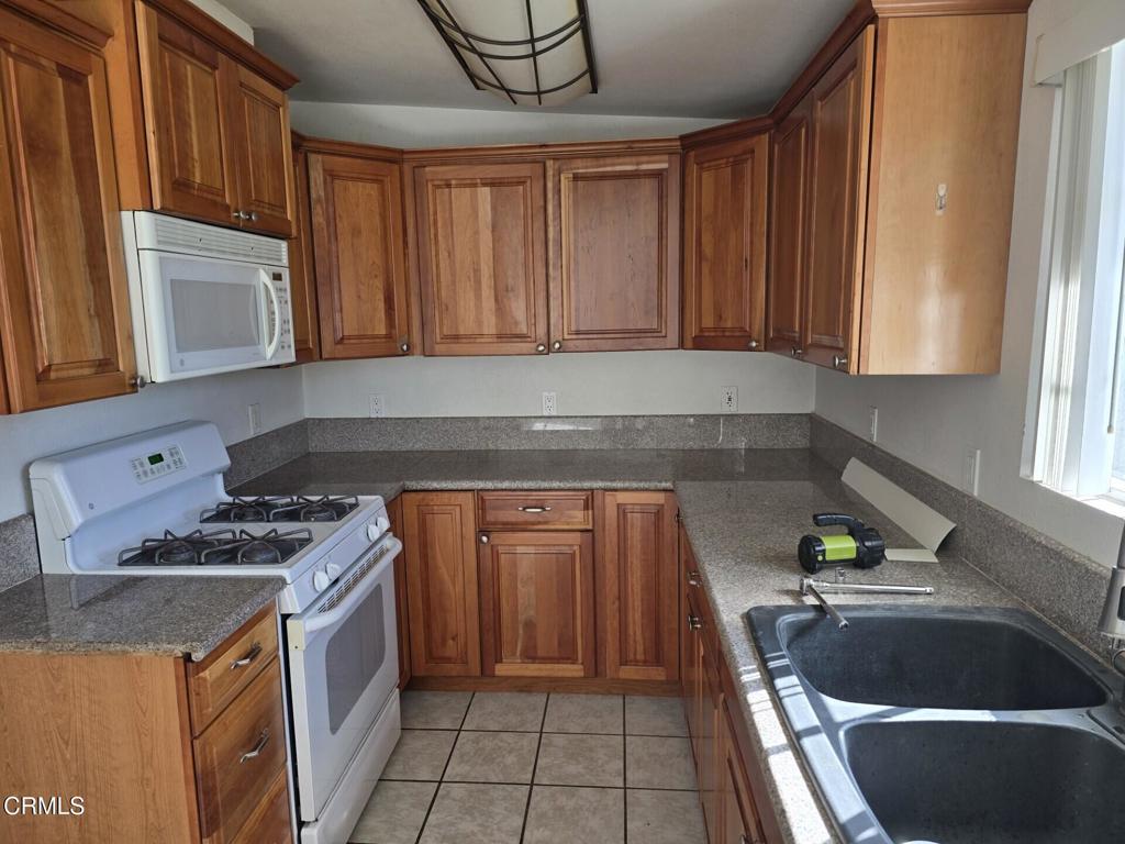 326 Simon Way Oxnard, CA 93036 - Photo 3 of 10 a kitchen with granite countertop a sink a stove and cabinets