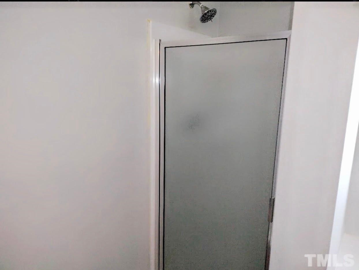 6041 Ricker Road Raleigh, NC 27610 - Photo 11 of 20 a bathroom with a glass shower door