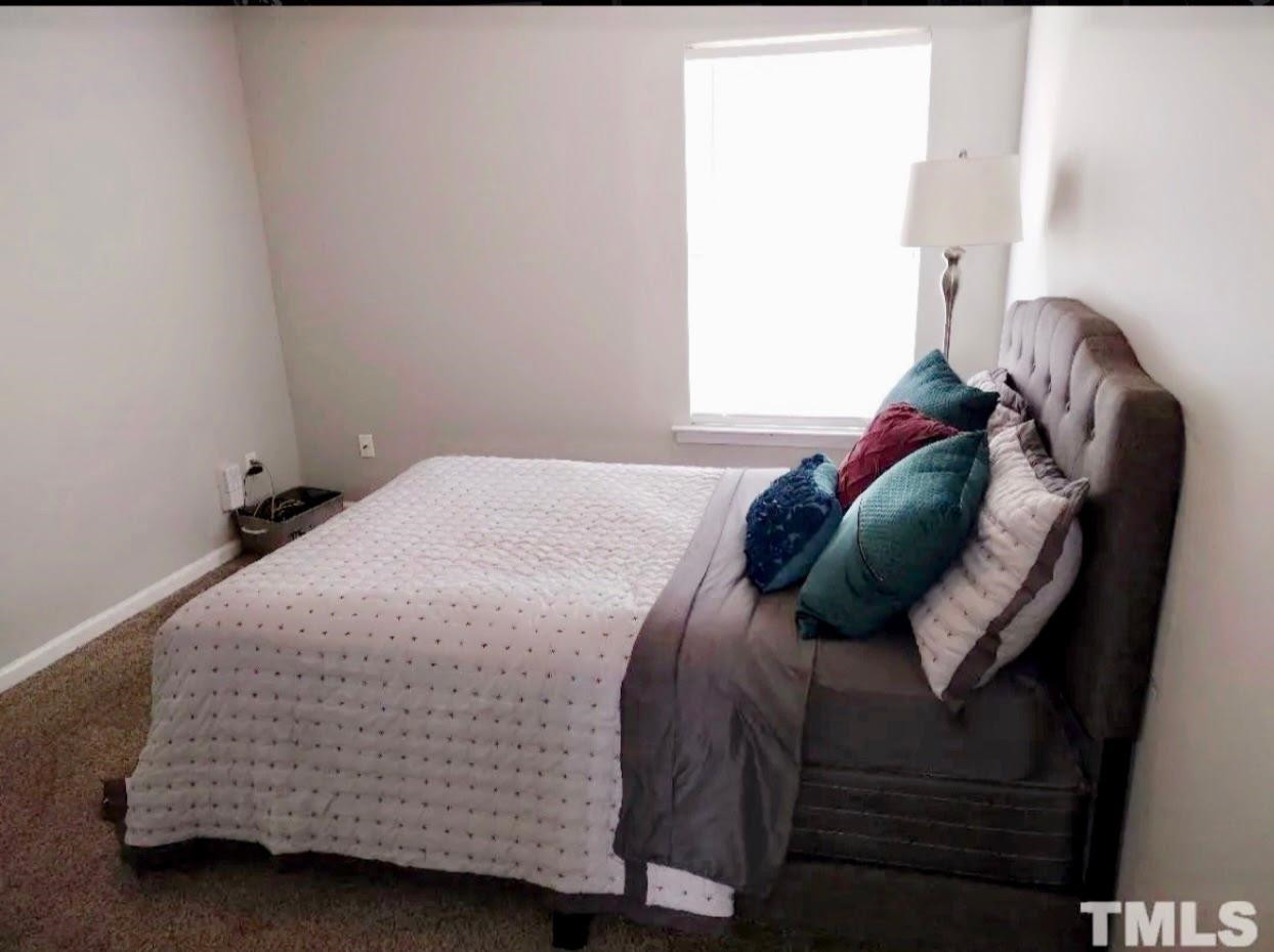 6041 Ricker Road Raleigh, NC 27610 - Photo 14 of 20 a bed sitting in a bedroom next to a window