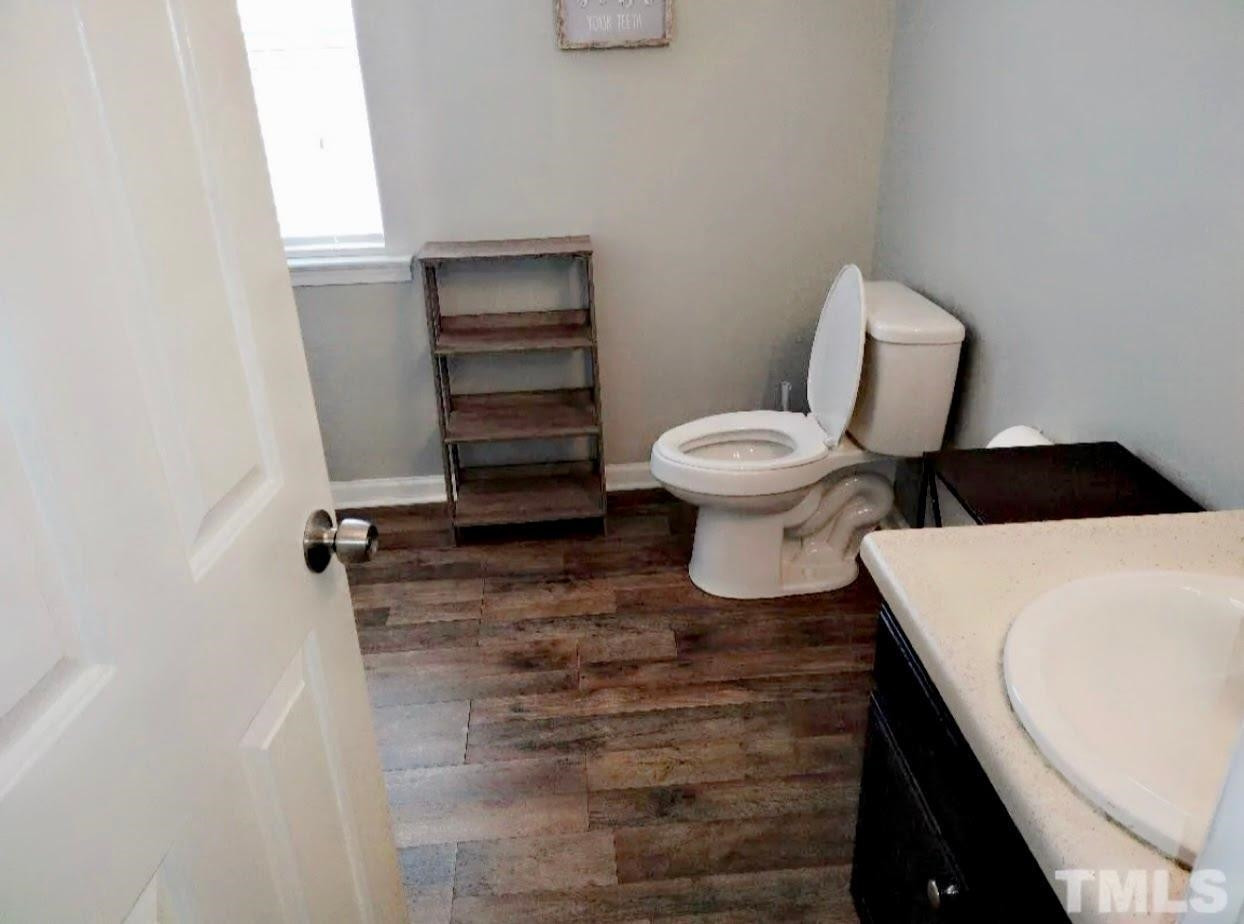 6041 Ricker Road Raleigh, NC 27610 - Photo 15 of 20 a bathroom with a toilet and a vanity