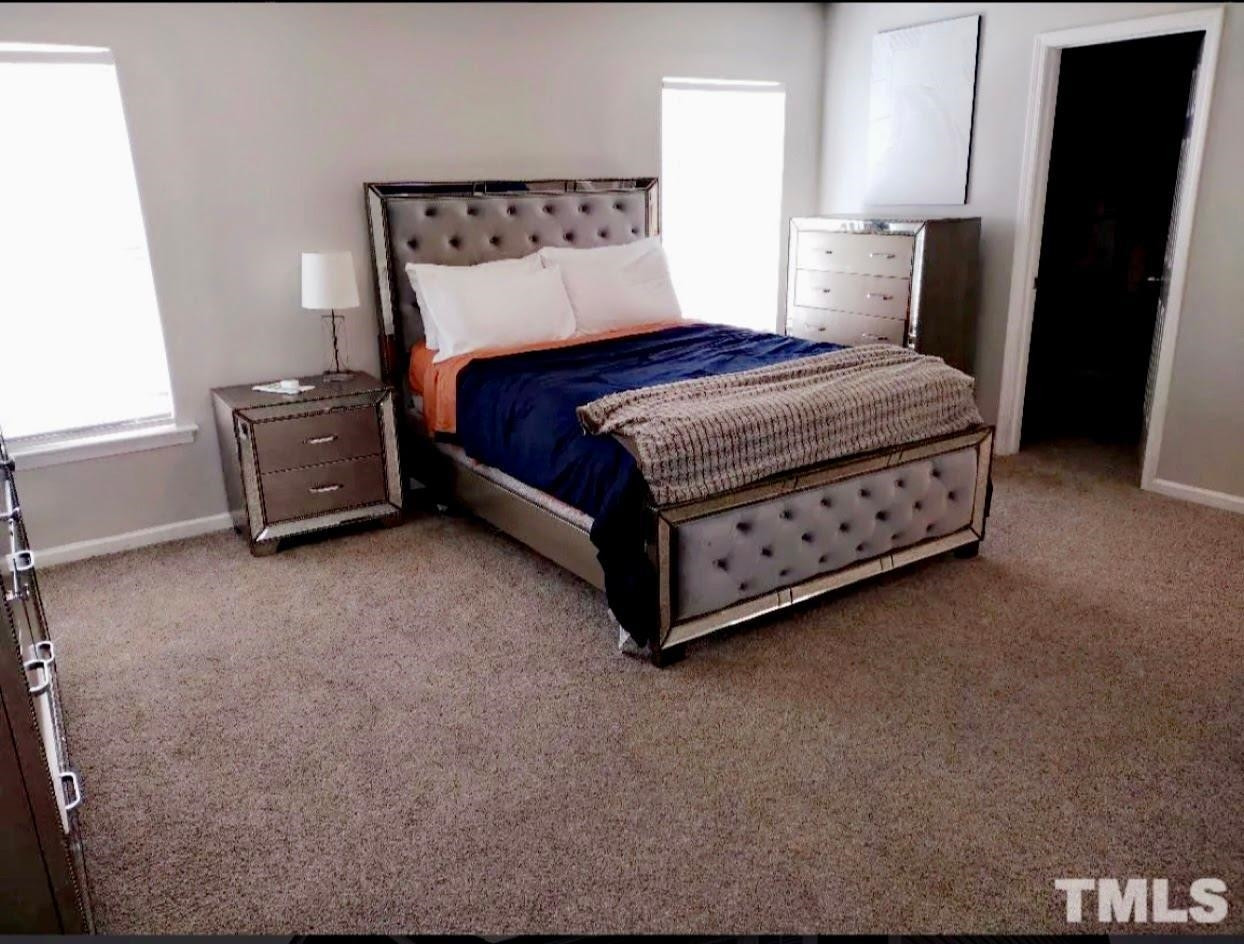 6041 Ricker Road Raleigh, NC 27610 - Photo 10 of 20 a bedroom with a bed and wooden floor
