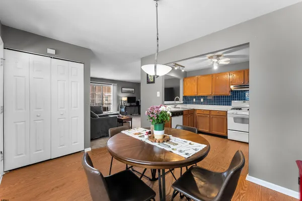a kitchen with a dining table chairs and white cabinets