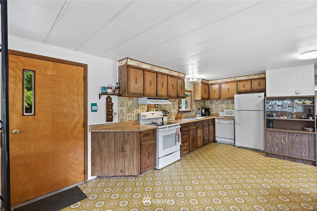 6960 Maxwelton Road Clinton, WA 98236 - Photo 24 of 40 a kitchen with a refrigerator and cabinets