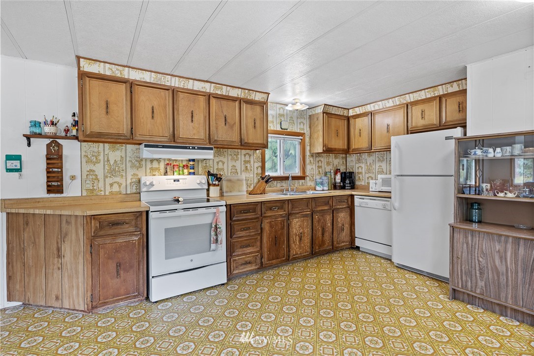 6960 Maxwelton Road Clinton, WA 98236 - Photo 25 of 40 a kitchen with a refrigerator sink and cabinets