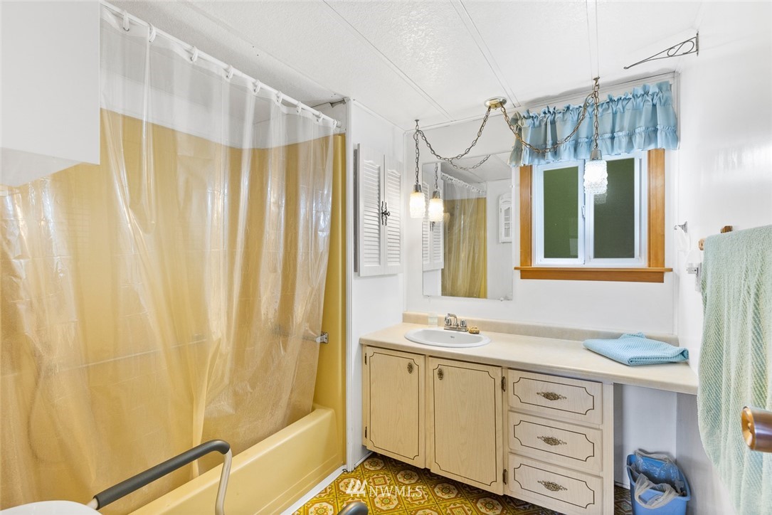 6960 Maxwelton Road Clinton, WA 98236 - Photo 29 of 40 a bathroom with a granite countertop sink and a mirror