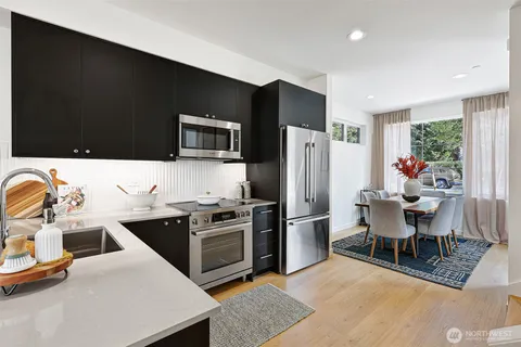 a kitchen with stainless steel appliances granite countertop a refrigerator stove microwave and sink