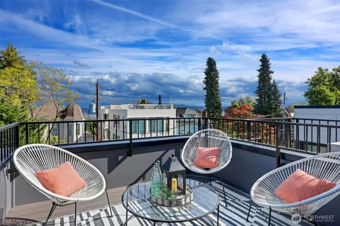 a balcony with wooden floor table and chairs
