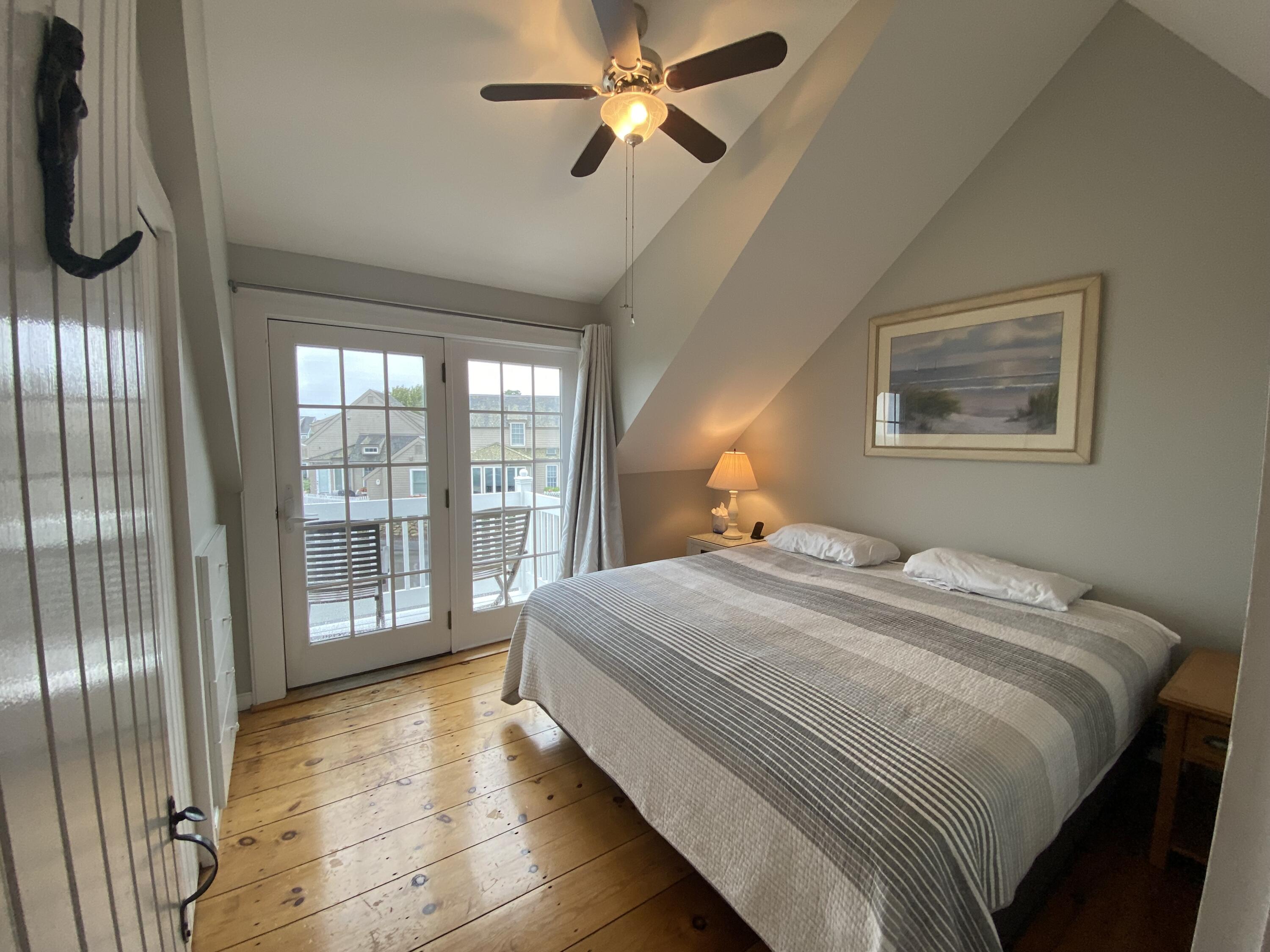 4 Race Point Road Mashpee, MA 02649 - Photo 28 of 37 a bedroom with a large bed and a chandelier fan