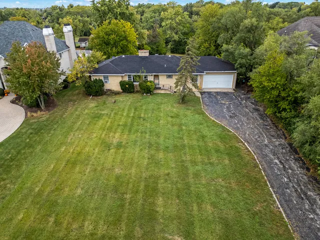 an aerial view of a house with a yard lake and outdoor seating