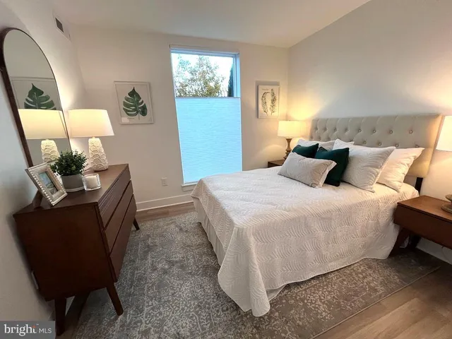 a bedroom with a bed a mirror and dresser