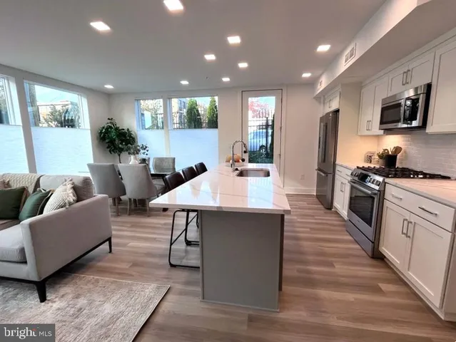 a large kitchen with stainless steel appliances lots of counter space and a sink